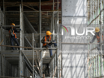 Construction workers are assembling steel structure roof trusses at the east station of Lushan Station of the Anjiu Section of the Beijing-H...