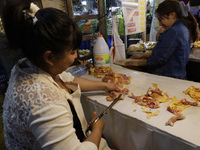 A woman is cutting chicken into pieces for sale at a market in Mexico City. Recently, the Ministry of Health of Tlaxcala in Mexico issued an...