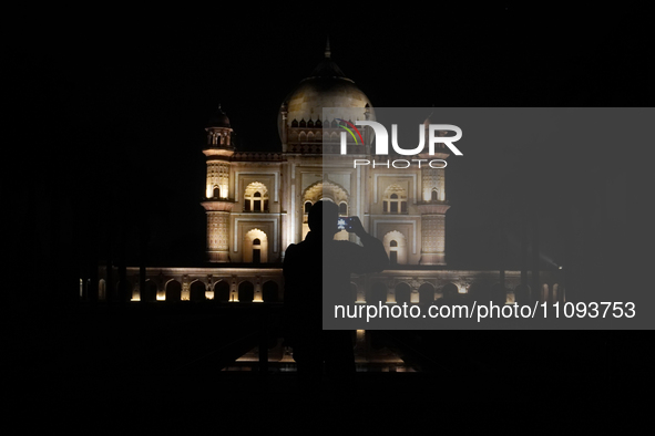 A media personnel is capturing an illuminated view of the Safdarjung Tomb before the Earth Hour environmental campaign in New Delhi, India,...