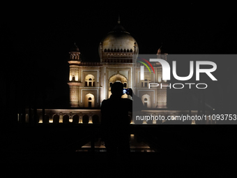 A media personnel is capturing an illuminated view of the Safdarjung Tomb before the Earth Hour environmental campaign in New Delhi, India,...