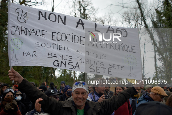 A man is holding a banner that reads 'No to the A69, ecocidal anachronic slaughter'. After spending 37 days in the trees, the last three 'Ec...