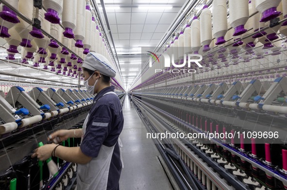 A worker is operating an intelligent production line at a textile company in Taizhou, Jiangsu Province, China, on March 26, 2024. 