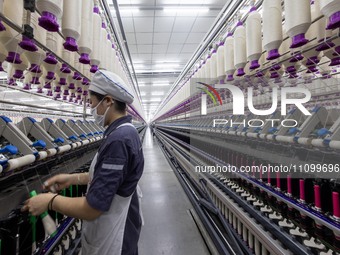 A worker is operating an intelligent production line at a textile company in Taizhou, Jiangsu Province, China, on March 26, 2024. (