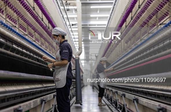 A worker is operating an intelligent production line at a textile company in Taizhou, Jiangsu Province, China, on March 26, 2024. 