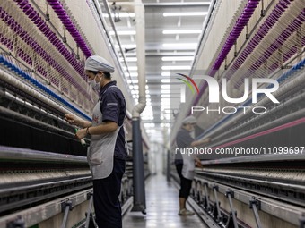 A worker is operating an intelligent production line at a textile company in Taizhou, Jiangsu Province, China, on March 26, 2024. (