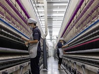 A worker is operating an intelligent production line at a textile company in Taizhou, Jiangsu Province, China, on March 26, 2024. (