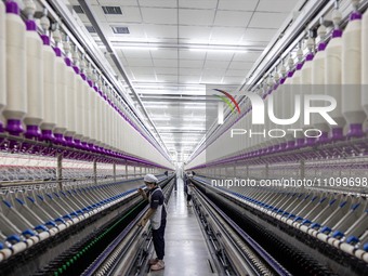 A worker is operating an intelligent production line at a textile company in Taizhou, Jiangsu Province, China, on March 26, 2024. (