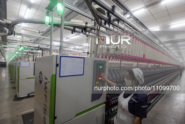 A worker is operating an intelligent production line at a textile company in Taizhou, Jiangsu Province, China, on March 26, 2024. 