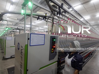 A worker is operating an intelligent production line at a textile company in Taizhou, Jiangsu Province, China, on March 26, 2024. (