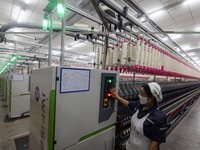 A worker is operating an intelligent production line at a textile company in Taizhou, Jiangsu Province, China, on March 26, 2024. (