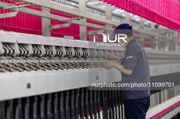 A worker is operating an intelligent production line at a textile company in Taizhou, Jiangsu Province, China, on March 26, 2024. 