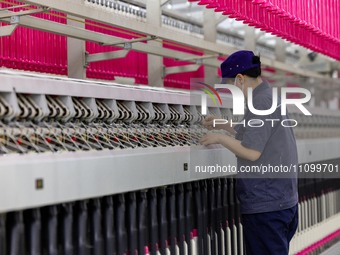 A worker is operating an intelligent production line at a textile company in Taizhou, Jiangsu Province, China, on March 26, 2024. (