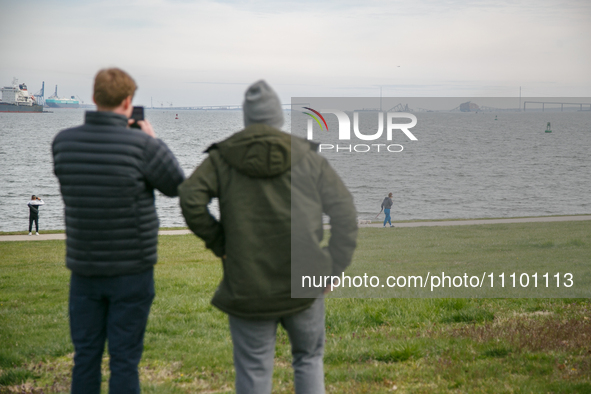 People view the collapsed Francis Scott Key Bridge in Baltimore, Maryland from the Fort McHenry National Monument and Historic Shrine on Mar...