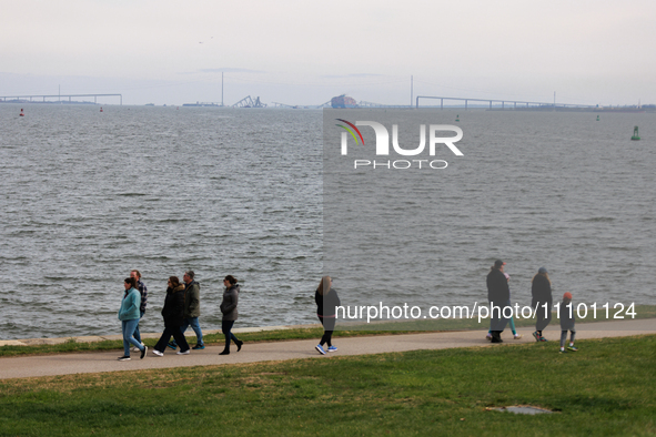 People view the collapsed Francis Scott Key Bridge in Baltimore, Maryland from the Fort McHenry National Monument and Historic Shrine on Mar...