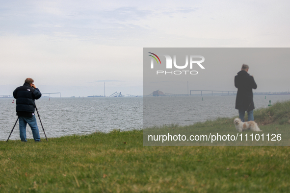 People view the collapsed Francis Scott Key Bridge in Baltimore, Maryland from the Fort McHenry National Monument and Historic Shrine on Mar...