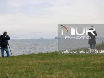 People view the collapsed Francis Scott Key Bridge in Baltimore, Maryland from the Fort McHenry National Monument and Historic Shrine on Mar...