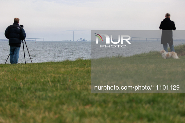 People view the collapsed Francis Scott Key Bridge in Baltimore, Maryland from the Fort McHenry National Monument and Historic Shrine on Mar...