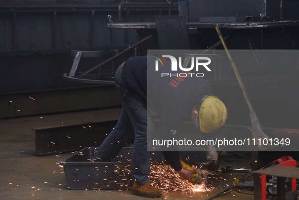 A worker is operating a self-developed water surface cleaning long-arm environmental protection ship at a shipping company's plant in Hangzh...