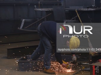 A worker is operating a self-developed water surface cleaning long-arm environmental protection ship at a shipping company's plant in Hangzh...