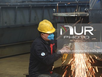 A worker is operating a self-developed water surface cleaning long-arm environmental protection ship at a shipping company's plant in Hangzh...