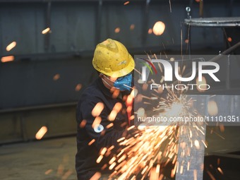 A worker is operating a self-developed water surface cleaning long-arm environmental protection ship at a shipping company's plant in Hangzh...