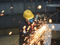 A worker is operating a self-developed water surface cleaning long-arm environmental protection ship at a shipping company's plant in Hangzh...