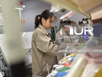 Workers are working on a production line of wiring harness products for complete vehicles at a workshop of a technology company in Fuyang, C...