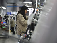 A worker is working on a production line of wiring harness products for a complete vehicle at a workshop of a technology company in Fuyang,...