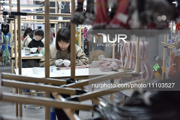 Workers are working on a production line of wiring harness products for complete vehicles at a workshop of a technology company in Fuyang, C...