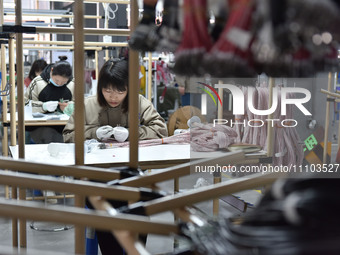 Workers are working on a production line of wiring harness products for complete vehicles at a workshop of a technology company in Fuyang, C...