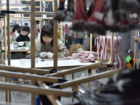 Workers are working on a production line of wiring harness products for complete vehicles at a workshop of a technology company in Fuyang, C...