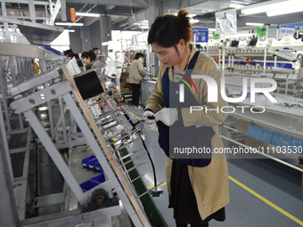 Workers are working on a production line of wiring harness products for complete vehicles at a workshop of a technology company in Fuyang, C...