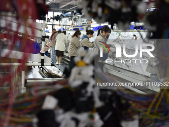 Workers are working on a production line of wiring harness products for complete vehicles at a workshop of a technology company in Fuyang, C...