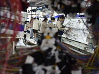 Workers are working on a production line of wiring harness products for complete vehicles at a workshop of a technology company in Fuyang, C...