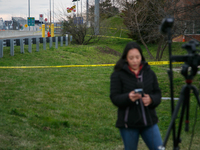 The collapsed Francis Scott Key Bridge is seen beyond a reporter at a media staging area at the Maryland Tansportation Authority headquarter...