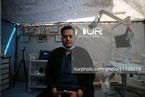 Palestinian dentist Najdat Saqr is treating his patients in a tent in the refugee camp in the central Gaza Strip on March 30, 2024, after hi...