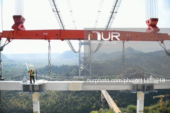 Workers are working at the construction site of Jinzhou Bridge in Xingyi, China, on March 31, 2024. 