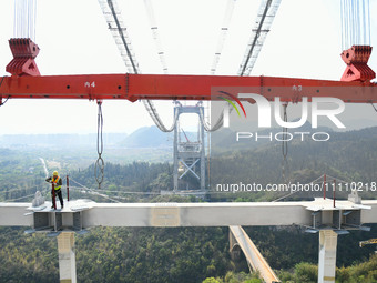 Workers are working at the construction site of Jinzhou Bridge in Xingyi, China, on March 31, 2024. (