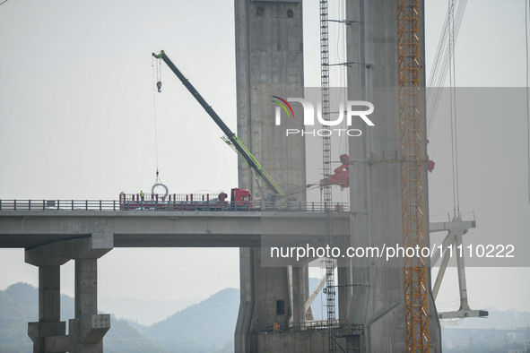 Workers are working at the construction site of Jinzhou Bridge in Xingyi, China, on March 31, 2024. 