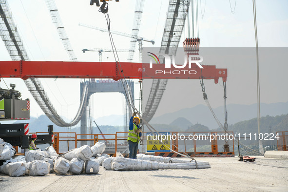 Workers are working at the construction site of Jinzhou Bridge in Xingyi, China, on March 31, 2024. 