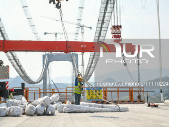 Workers are working at the construction site of Jinzhou Bridge in Xingyi, China, on March 31, 2024. (