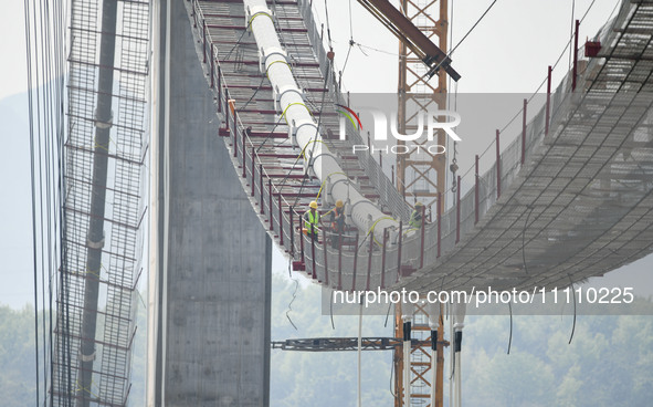 Workers are working at the construction site of Jinzhou Bridge in Xingyi, China, on March 31, 2024. 