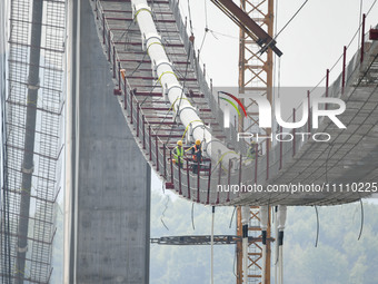 Workers are working at the construction site of Jinzhou Bridge in Xingyi, China, on March 31, 2024. (