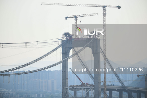 Workers are working at the construction site of Jinzhou Bridge in Xingyi, China, on March 31, 2024. 