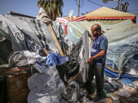 Palestinians are checking the damage at a makeshift camp for displaced people in front of the Al-Aqsa Martyrs Hospital in Deir al-Balah in t...