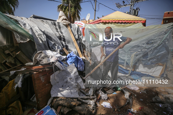 Palestinians are checking the damage at a makeshift camp for displaced people in front of the Al-Aqsa Martyrs Hospital in Deir al-Balah in t...