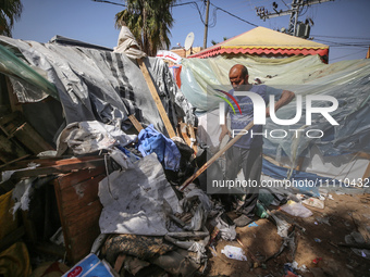 Palestinians are checking the damage at a makeshift camp for displaced people in front of the Al-Aqsa Martyrs Hospital in Deir al-Balah in t...