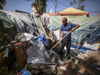 Palestinians are checking the damage at a makeshift camp for displaced people in front of the Al-Aqsa Martyrs Hospital in Deir al-Balah in t...