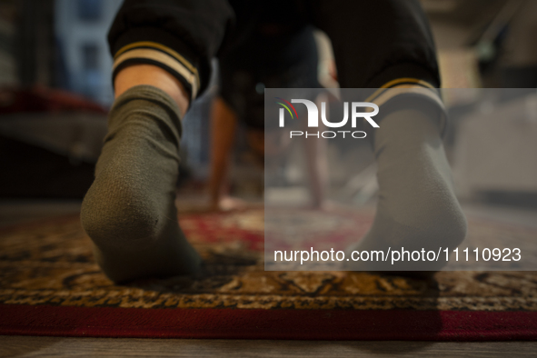 A woman is seen doing yoga exercises with YouTube trainer on a television in her living room in Warsaw, Poland on 23 March, 2024. 