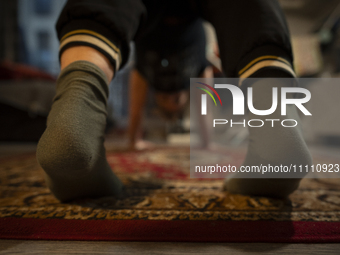 A woman is seen doing yoga exercises with YouTube trainer on a television in her living room in Warsaw, Poland on 23 March, 2024. (